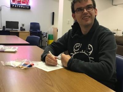 photo of a member of the Clubhouse sitting around the board table