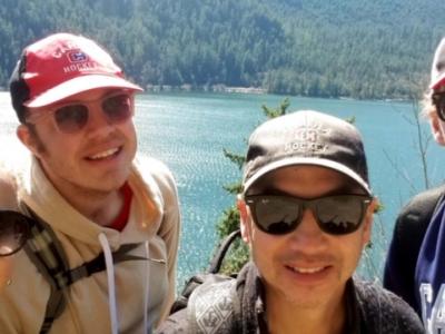 group of young adults on a hike above a lake