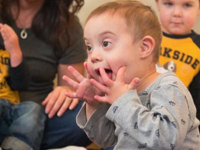 photo of infant with hands on his face