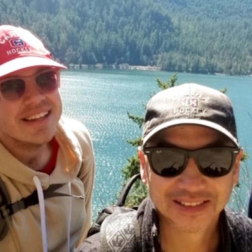 group of young adults on a hike above a lake