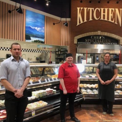 photo of grocery store staff standing with social distancing