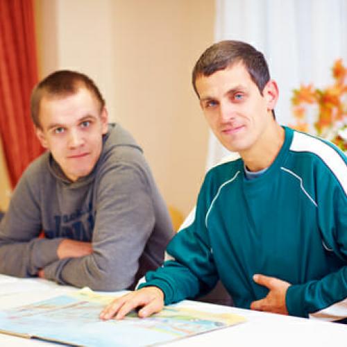 picture of 2 men studying a book