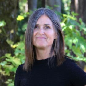 A woman in a black shirt smiling